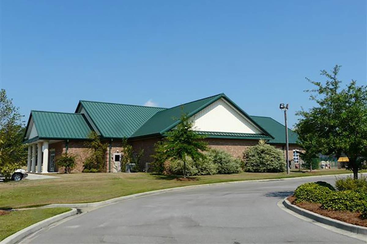A metal building day care facility in Sumter, South Carolina, features a green standing seam roof with valleys and canopies.