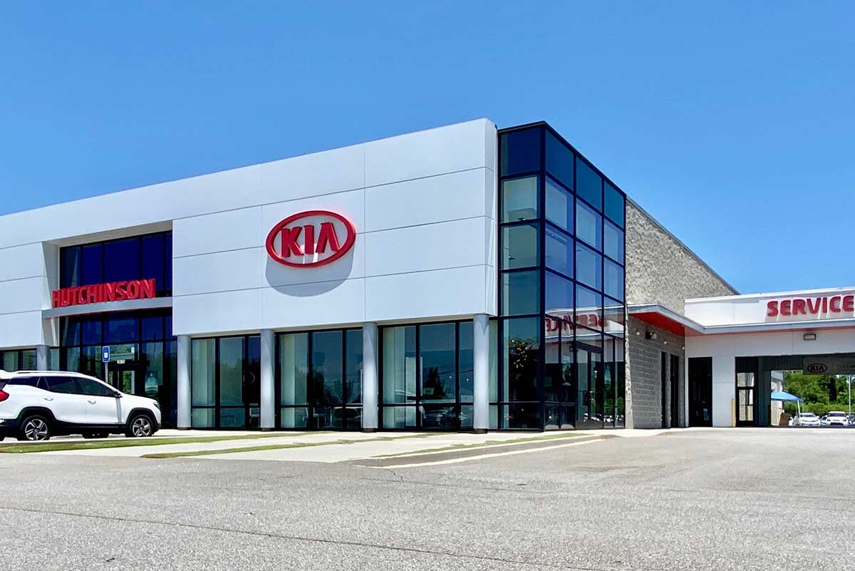 The Hutchinson Kia dealership in Albany, Georgia is a weathertight metal building with large windows and red accents. 